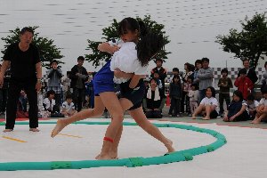 土俵際で組み合う女子児童の画像