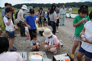 おにぎりや漬物を食べている参加者の画像