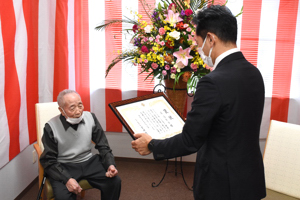 100歳を迎えたおじいさんに褒状を読み上げる宮崎市長の画像