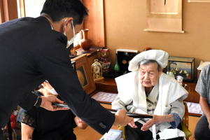 100歳を迎えたおばあさんに褒状を手渡す宮崎市長の画像