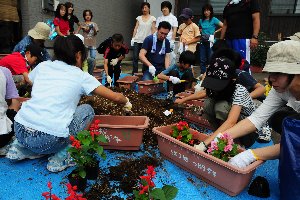 プランターに花を植える子どもたちの画像