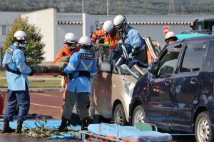 事故車両から消防隊員が負傷者を救出している画像