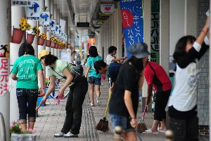 通りを掃除する参加者の画像