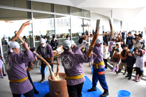 東山五人杵搗き餅保存会による餅つきを見る子どもたちの画像