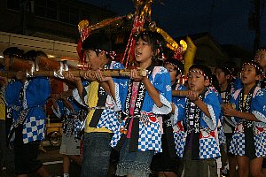 元気よく神輿をかつぐ子どもたちの画像