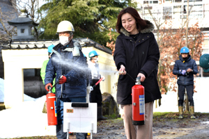 消火器操作訓練を行う女性の画像