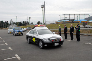 パトカーを先頭にパトロールに出発する車両の画像