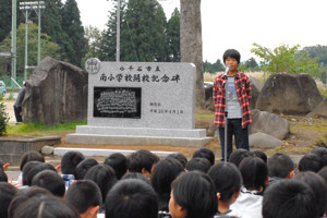 記念碑の前で代表のあいさつをする羽鳥さんの画像