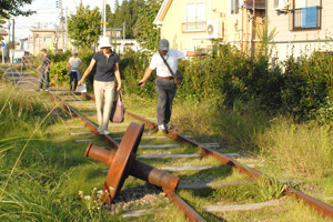 保存されている鉄道のレールを歩く参加者の画像