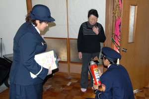 消火器の点検をする消防署員の画像