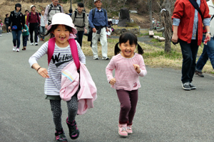 笑顔で坂を登る子どもの画像