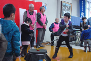 こま回しに挑戦する男の子の画像