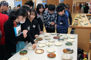 自分の作った器を見る小学生の画像