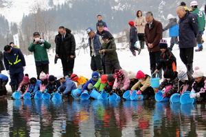 鮭の稚魚を放流する児童の画像