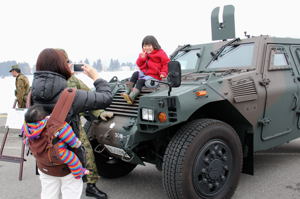 自衛隊展示車両で記念撮影をする子どもの画像