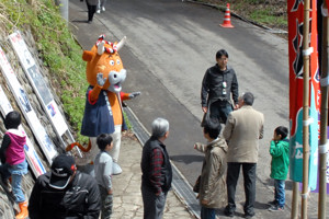 会場前で観客を出迎える「よし太くん」の画像