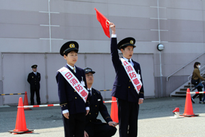 旗をあげて合図している小学生の画像