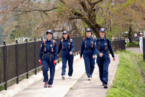 制服を着て歩く女性消防団員の画像