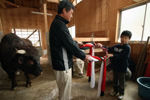 牛太郎への面綱を渡す児童の画像