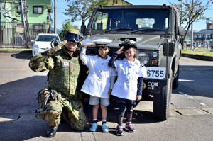 陸上自衛隊の車両で記念撮影をする子どもの画像