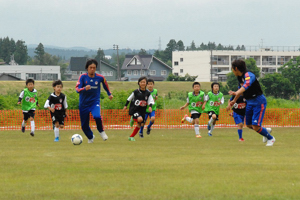 2人の選手と一緒にゲームをする子どもたちの画像