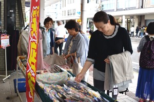 店先の商品を見る女性の画像