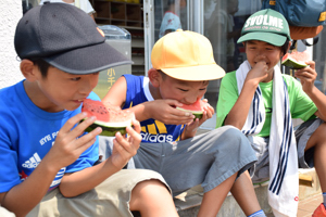 スイカを食べる子どもたちの画像