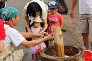 餅つき体験に参加する来場者の画像