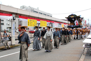 二荒神社へ向かう巫女爺屋台と保存会のみなさんの画像