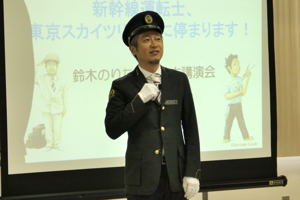 新幹線運転士の制服で話をする鈴木さんの画像