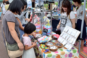 フリーマーケットで品定めをする来場者の画像