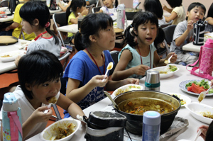 出来上がったカレーを食べる児童たちの画像