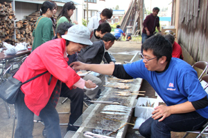 サンマを焼いている来場者の画像