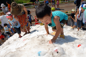 雪山でおもちゃの入ったカプセルを見つける子どもの画像