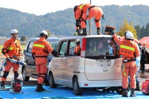 事故車両からの救出訓練で、消防隊員が車両の天井を切りとっている画像